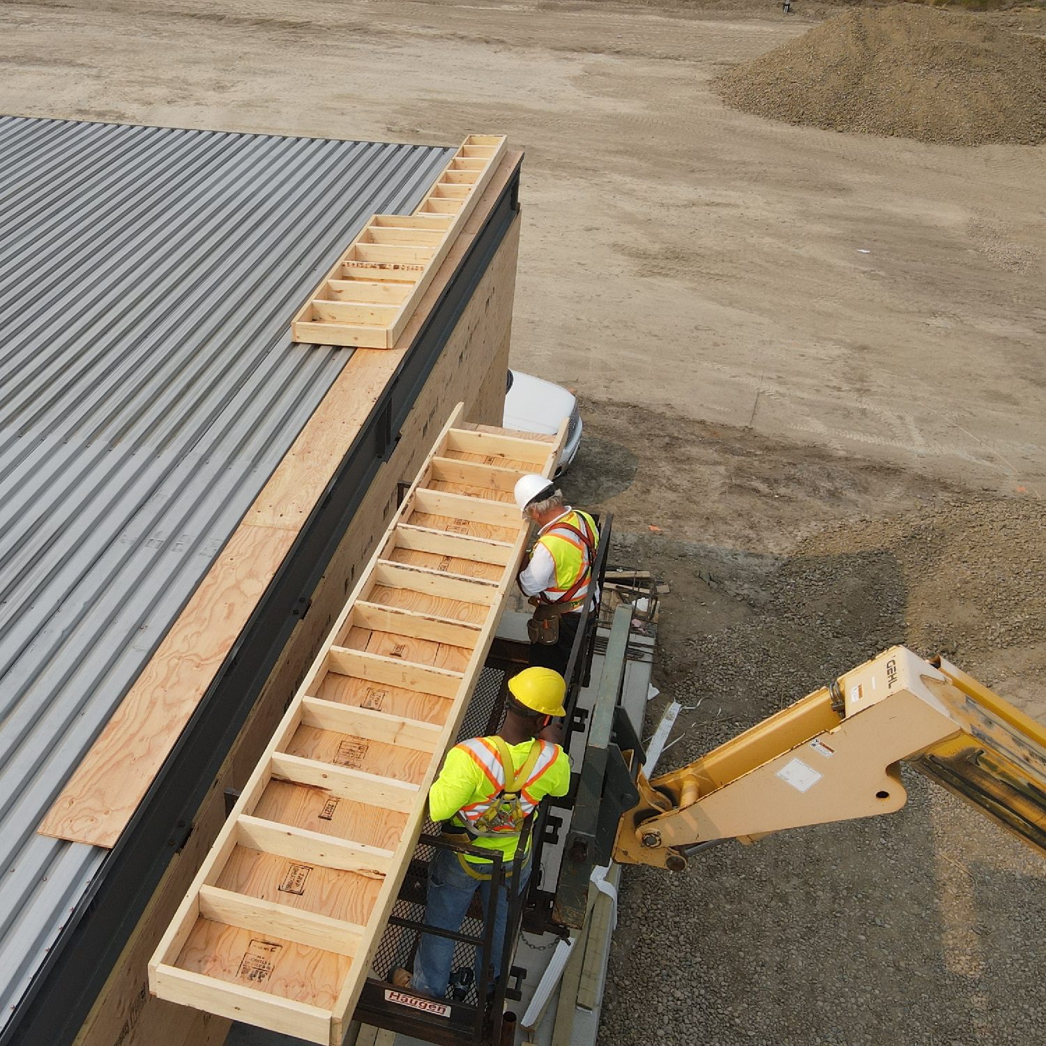 Construction workers on lift wearing safety equipment